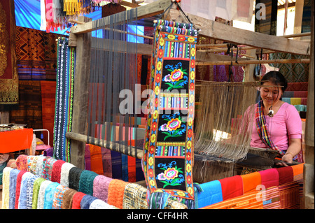 Young woman working on handmade silk fabrics in a village nearby Pak Ou caves obove Mekong river north of Luang Prabang, Laos Stock Photo