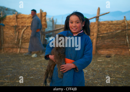 Young Mongolian girl in traditional costume (deel) with her goat, Province of Khovd, Mongolia, Central Asia, Asia Stock Photo