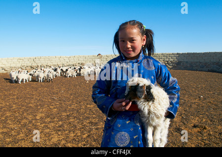 Young Mongolian girl in traditional costume (deel) with her sheep, Province of Khovd, Mongolia, Central Asia, Asia Stock Photo