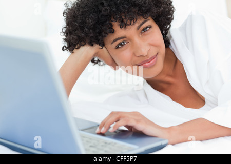 Portrait of a cute black haired woman lying on her bed Stock Photo