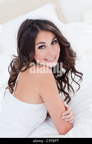 Smiling young bride looking over her shoulder Stock Photo