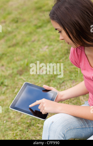 Young serious woman using her tablet pc in a park Stock Photo