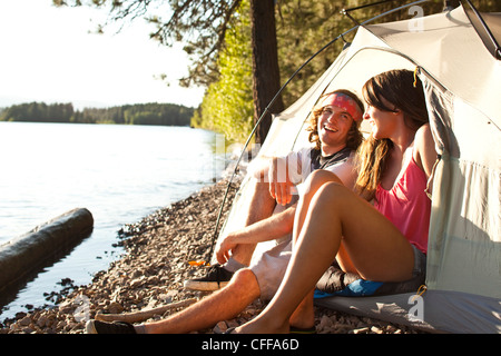 Two young adults laugh and smile on a camping and kayaking trip in Idaho. Stock Photo