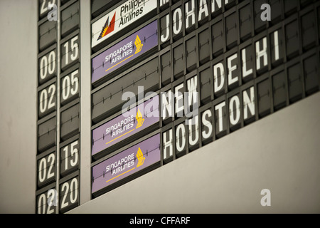 Flight departure and arrival information on electronic monitors at Changi Airport in Singapore Stock Photo