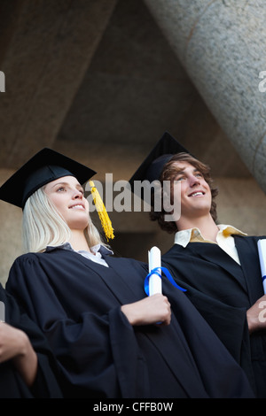 Low-angle view of happy graduating students Stock Photo
