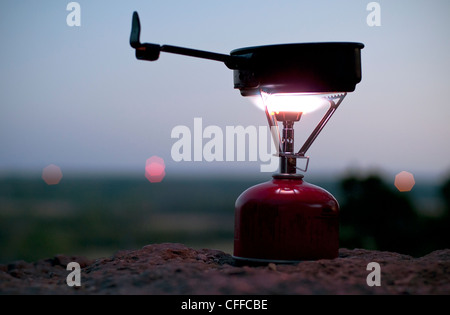 A camp stove illuminates the dusk evening on top of a bluff at Dynosaur State Park near Glen Rose, Texas. Stock Photo