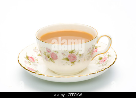Flowery china cup and saucer with tea in it on a white background. Stock Photo