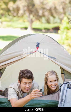 A man pointing something out to his girlfriend while they are in the tent Stock Photo