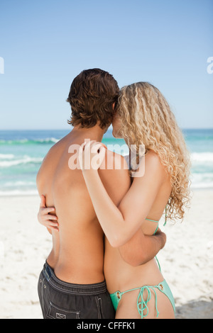 Back view of a couple standing in front of the sea Stock Photo