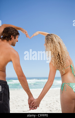 Young couple joining their hands while making a heart shape Stock Photo