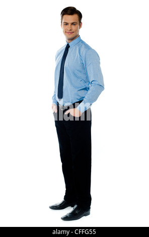 Handsome young business associate standing with hands in his pocket Stock Photo