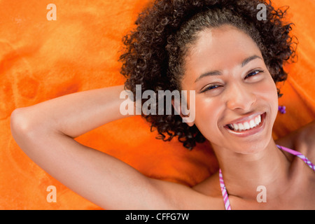 Young smiling woman looking at the camera while lying down Stock Photo