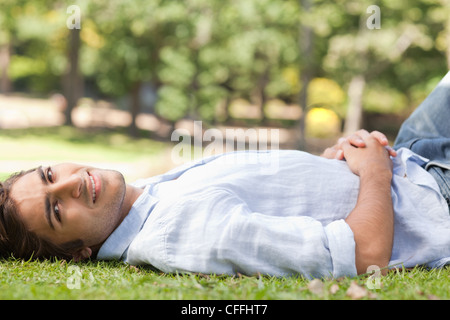 Side view of smiling man relaxing on the lawn Stock Photo