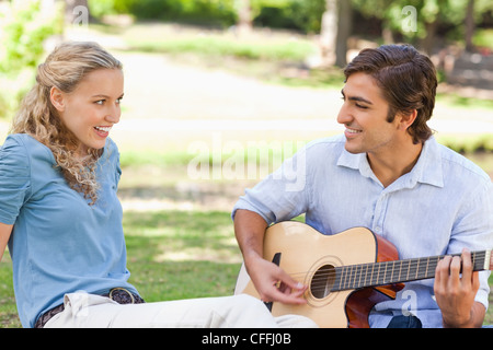 Man playing the guitar for his girlfriend Stock Photo