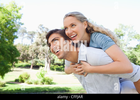 Man carrying his girlfriend on his back Stock Photo
