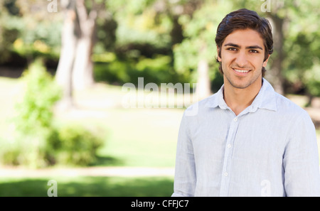 Smiling man standing in the park Stock Photo