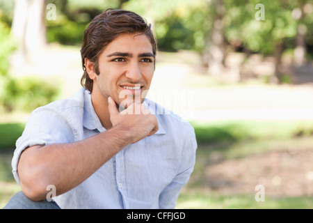 Thoughtful man sitting in the park Stock Photo