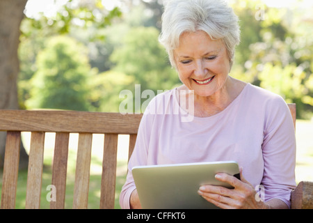 Woman smiling while using a tablet Stock Photo