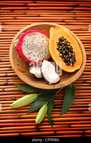 Dragon fruit, Papaya and Coconut in wooden bowl on bamboo background Stock Photo