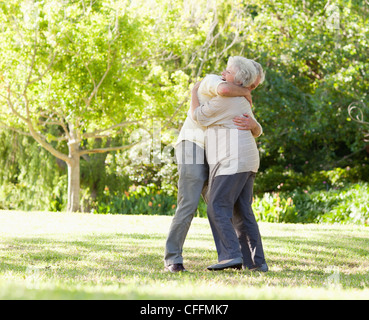 Two friends hugging each other in a park Stock Photo
