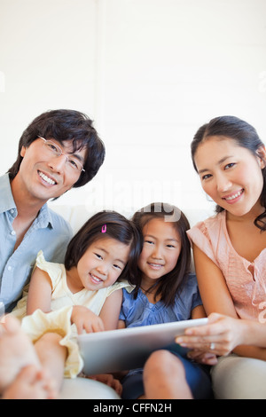 Close up of a happy family using a tablet and smiling Stock Photo