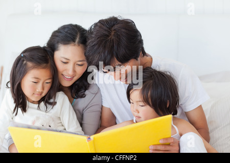 Close up of a family reading a story while on the bed Stock Photo