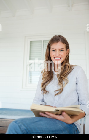 Close up of a woman smiling with a book in her hands Stock Photo