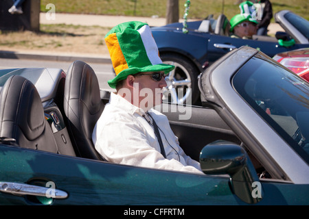 A man wearing an Irish colors hat in a convertible car Stock Photo