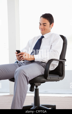 Smiling businessman using his smartphone Stock Photo