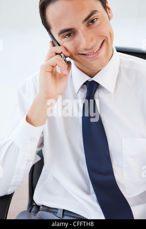 Smiling businessman calling using his smartphone Stock Photo