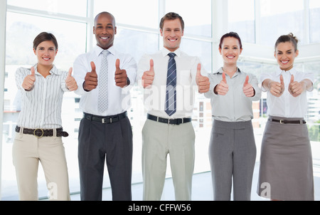 Smiling Business team giving thumbs up Stock Photo