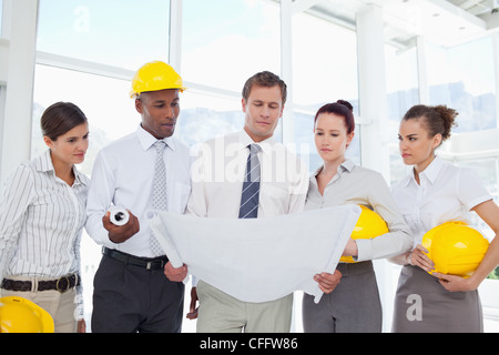 A group of architects reading off from some blueprints Stock Photo