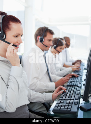 Call center employees sitting in a line Stock Photo
