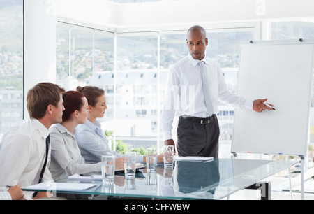Businessman giving a presentation for his colleagues Stock Photo