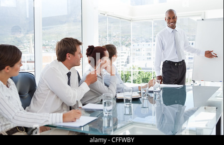 Smiling businessman giving a presentation for his colleagues Stock Photo
