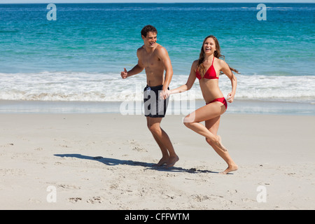 Funny couple running on the beach Stock Photo