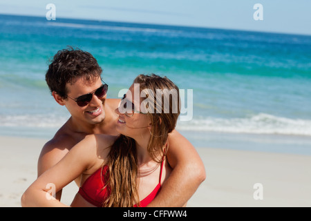 Beautiful lovers at the beach wearing sunglasses Stock Photo