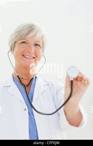 Smiling doctor using her stethoscope Stock Photo