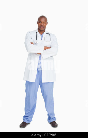 Smiling doctor standing with his arms folded Stock Photo