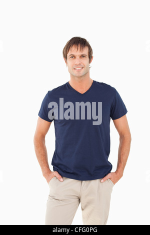 Smiling man standing upright with his hands in his pockets Stock Photo