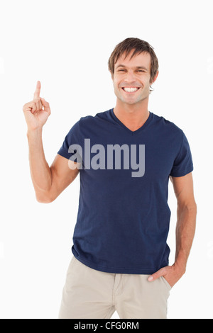 Smiling man looking at the camera while pointing his finger up Stock Photo