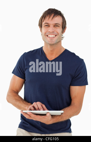 Smiling man holding a tablet pc while looking at the camera Stock Photo
