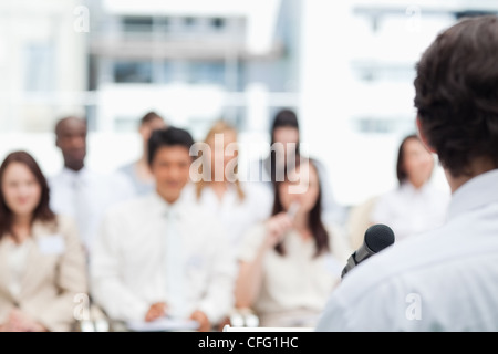 Businessman giving a speech in front of his colleague Stock Photo