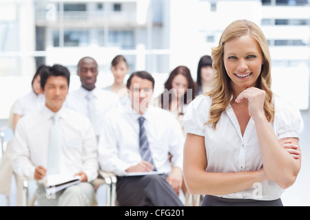 Smiling businesswoman resting her chin on her hand Stock Photo