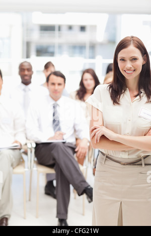 Brown haired businesswoman smiling as she crosses her arms Stock Photo
