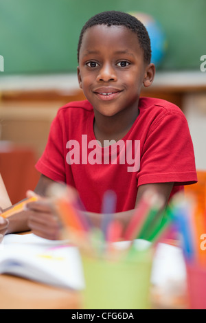 Smiling student sitting at desk during class Stock Photo