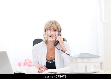 Happy senior architect woman having good news phone call Stock Photo