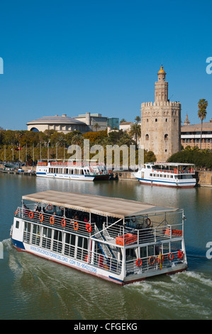 Sightseeing tour cruise boat in front of Torre del Oro tower (13th century) by River Guadalquivir central Seville Stock Photo