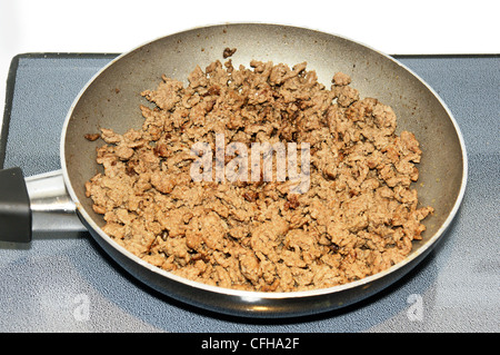 Close up of lean ground beef meat being cooked in a teflon pan over ceramic cook top. Stock Photo