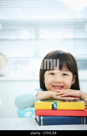 A girl having her hands on the pile of books Stock Photo - Alamy